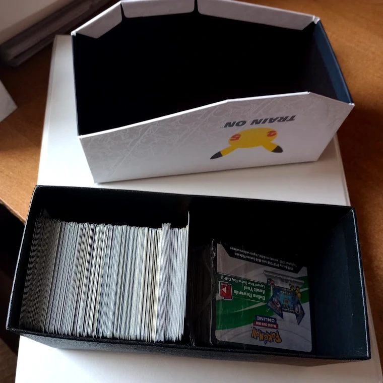 posegregowana kolekcja kart pokemon trading game, karty są umieszczone w pudełku po elit trainer box, z którego usunięto zawartość